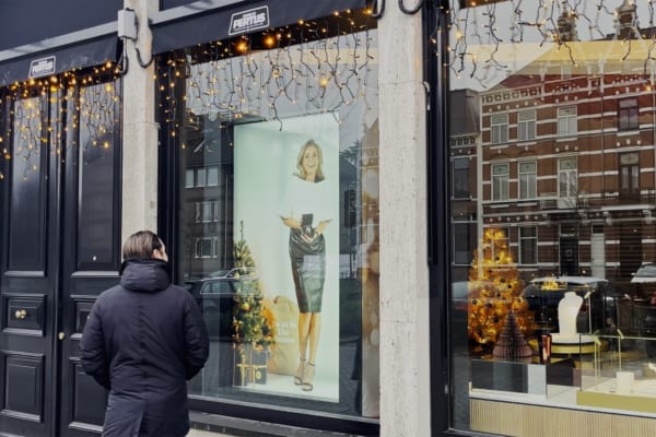 A person standing outside a store window AI-generated content may be incorrect.